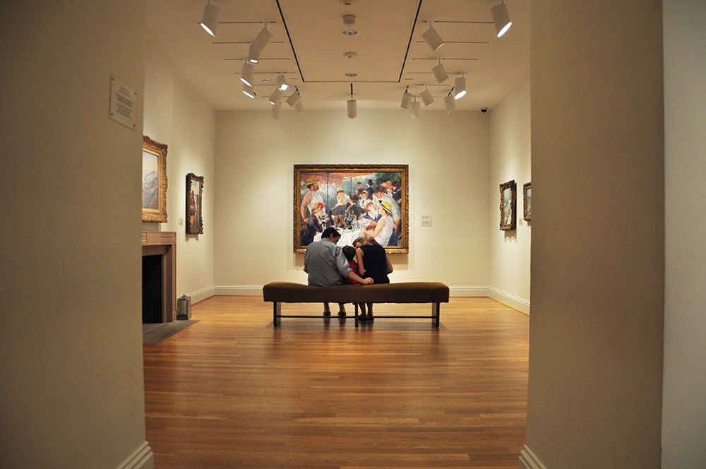Photograph of a family looking at Renoir's Luncheon of the Boating Party