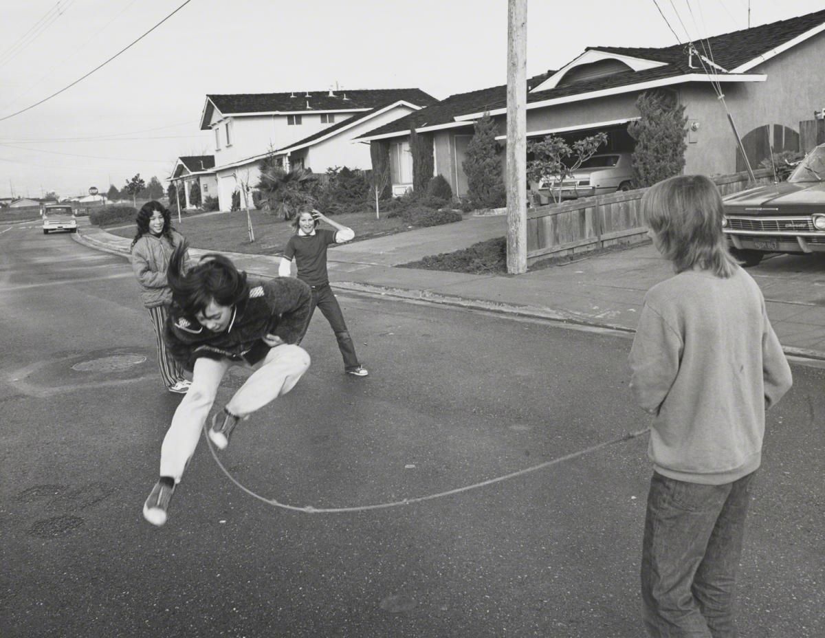 Bill Owens, Untitled (Kids in street jumping rope), 1971.